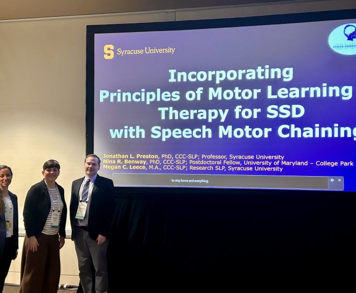 Nina, Megan, and Jon in front of their presentation slides at ASHA